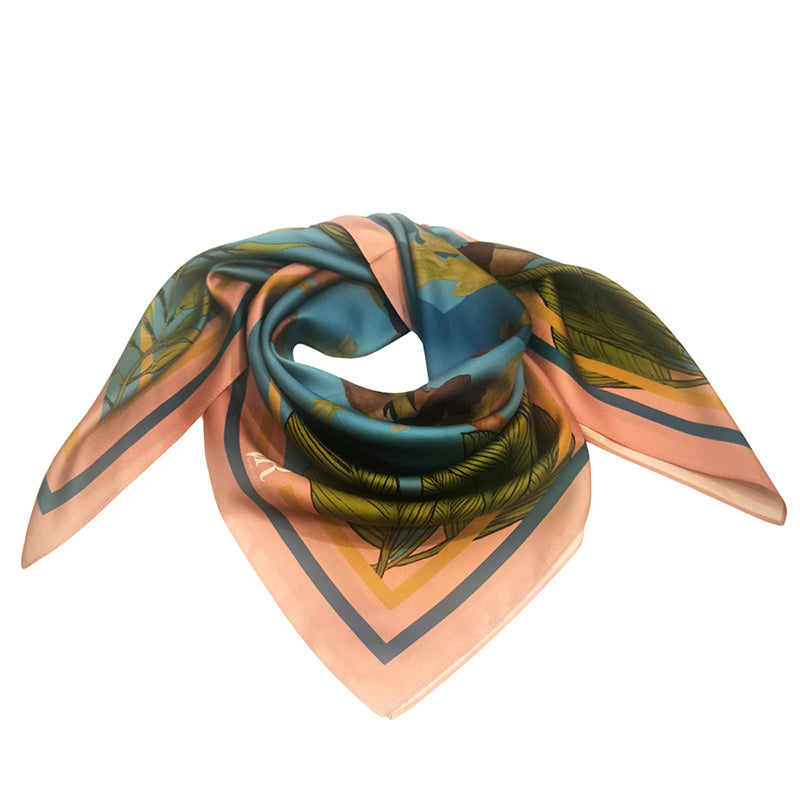 Delicate and soft silk Twill scarf with one Mona Monkey illustration in the centre surrounded by the sea and tropical green leaves in vibrant blue and yellow in pale pink edges with two tones blue background .90cm x 90cm